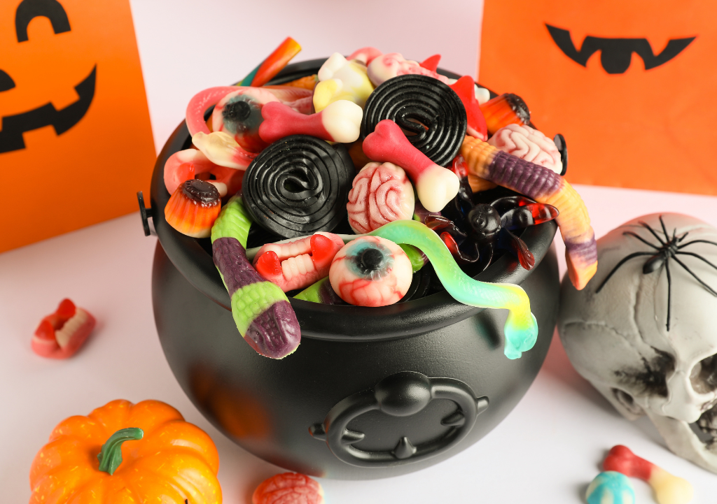 Calabaza de Halloween con caramelos y gominolas junto a un cepillo de dientes.